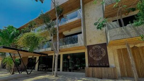 A modern building with a sign reading "Hotel de la Costa". - HEAVENLY MAYAN ESCAPE CHIC 1 BDRM APT 250 MB WiFi IN HEART OF TULUM, PLUNGE POOL (Tulum)