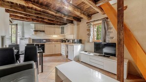 A compact kitchen with modern appliances, a dining area with a table and chairs, and a TV. - Lovely home in Mont-Dol with WiFi (Mont-Dol)