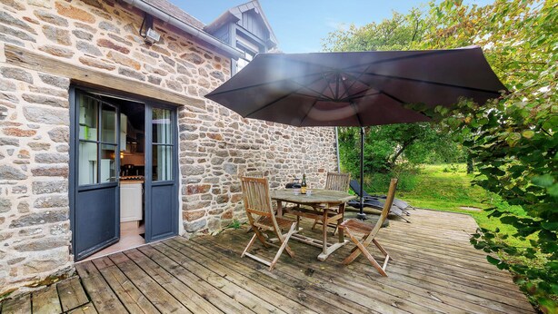 A stone building with a wooden deck and outdoor seating area. - Lovely home in Mont-Dol with WiFi (Mont-Dol)