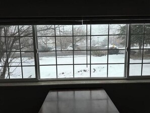 A room with a large window overlooking a snowy outdoor scene.