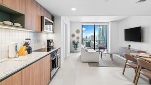 A modern kitchen with a built-in oven and a dining area with a view of the city. - Luxury unit / amazing view to Downtown/ floor 26th (Miami)