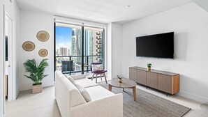 A modern living room with a sofa, a coffee table, and a TV mounted on the wall. - Luxury unit / amazing view to Downtown/ floor 26th (Miami)