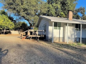 Ein bungalow mit Veranda und Schornstein.