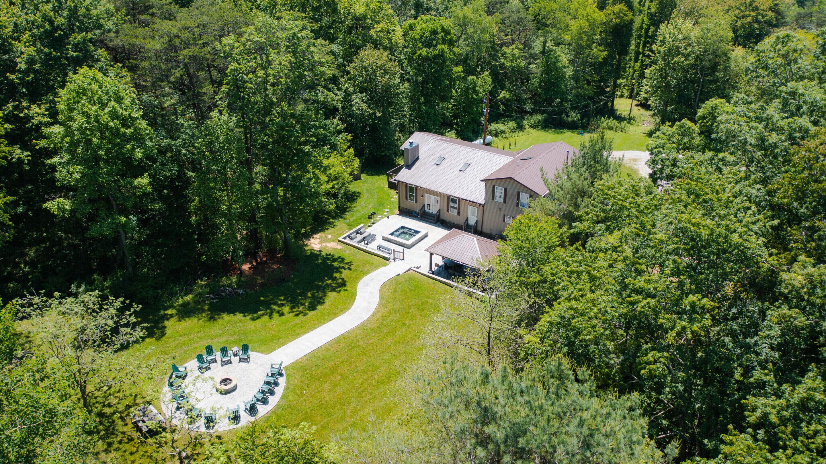 A house with a patio area, a hot tub, and a circular seating arrangement.