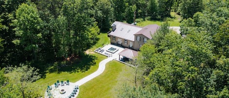 A house with a patio area, a hot tub, and a circular seating arrangement.