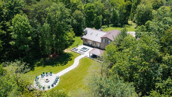 A house with a patio area, a hot tub, and a circular seating arrangement.