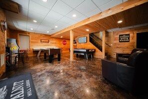 A wooden interior with a pool table, a ping pong table, and a sign reading 'Welcome to the Woods.' - Walnut Hill Lodge | Hocking Hills Luxury, Hot Tub (Logan)
