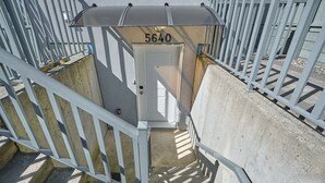 A stairway leading to a door marked with the number 5640, surrounded by white metal railings. - Basement Suite in Vancouver (Vancouver)