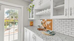 A kitchen with white cabinets, a granite countertop, a window, and a view of the outdoors. - Mermaid Cottage: 5 mi. from beach, fully stocked 3br, grill, deck, bunk bed (Fort Walton Beach)