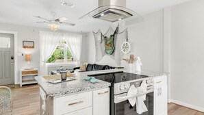 A modern kitchen with a central island, built-in oven, and a ceiling fan. - Mermaid Cottage: 5 mi. from beach, fully stocked 3br, grill, deck, bunk bed (Fort Walton Beach)