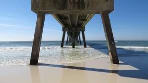 The underside of a concrete pier with multiple pillars extending into the ocean. - Mermaid Cottage: 5 mi. from beach, fully stocked 3br, grill, deck, bunk bed (Fort Walton Beach)