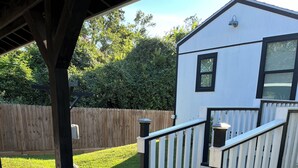 Il s’agit d’une propriété résidentielle dotée d’un patio couvert, d’une façade blanche et d’une clôture en bois.