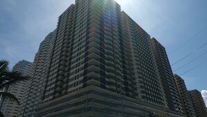 Un edificio alto con varios balcones y un cielo despejado.