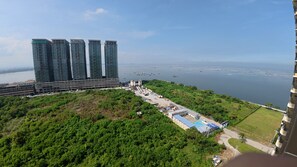 A high-rise building with multiple balconies and a marina in the background. - Golden Seagulls Hotel (Parañaque)