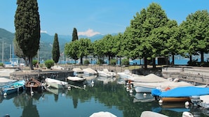 A marina with boats docked, surrounded by trees and a clear view of the water. - Vacation home Eden by Interhome (San Felice del Benaco)