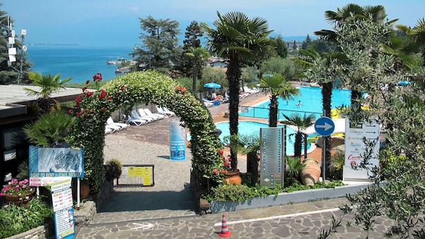 A resort with a pool, lounge chairs, and a view of the sea. - Vacation home Eden by Interhome (San Felice del Benaco)