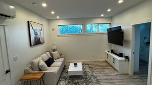 Een moderne woonkamer met een bank, salontafel en tv-meubel.