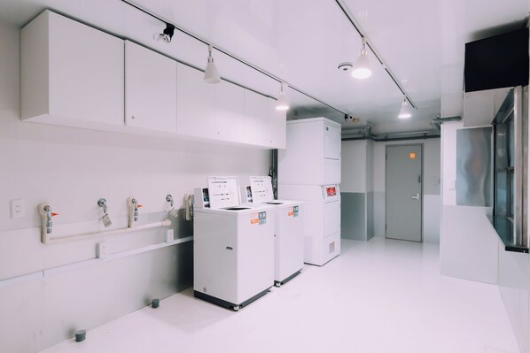 A clean, modern kitchen with white cabinets, stainless steel appliances, and a bright, well-lit environment. - Minimalist Loft 901 (Osaka)