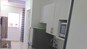 Una cocina moderna con refrigerador, estufa, microondas y gabinetes oscuros.