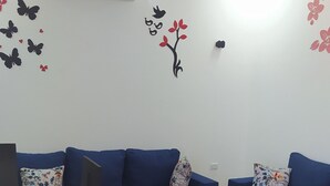 Una sala moderna con dos sofás azules, una mesa de centro de madera y una alfombra negra.