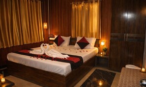 A hotel room with a large bed, wooden headboard, and curtains. - Sea Pearl Homestay (Port Blair)