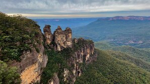 A panoramic view of a mountainous landscape with prominent rock formations and dense forest. - Newtown Family Stay | 6 Beds + Ducted Aircon (Newtown)