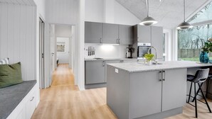 A modern kitchen with grey cabinets, a central island, and a large window.