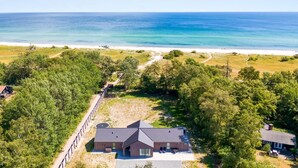 A coastal property with a main building, a secondary structure, and a beach path.
