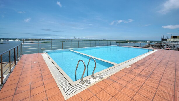 A swimming pool with metal railings and a tiled deck. - Spacious 3-bedroom water front apartment in serene Marine Drive Ernakulam Kerala (ERNAKULAM)
