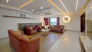 A modern living room with a sofa set, a coffee table, and a TV. - Spacious 3-bedroom water front apartment in serene Marine Drive Ernakulam Kerala (ERNAKULAM)