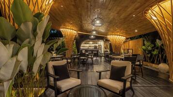 A cozy indoor seating area with wooden flooring, cushioned chairs, and a central round table.