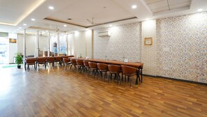 A conference room with a long table, chairs, and a patterned wall. - Fabhotel Prime Culture (Noida)