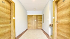 A hallway with wooden double doors, each marked with a number. - Fabhotel Rush Imperial (Indore)