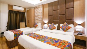 Une chambre d’hôtel avec deux lits, un mur décoratif en briques et un ventilateur de plafond.