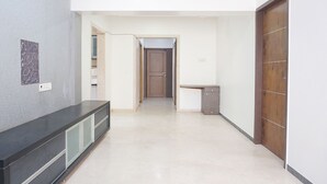A hallway with a dark counter, a wooden door, and a small cabinet. - Fabhotel Shree Haree Residency (Pune)