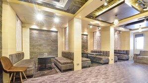 A spacious lounge area with multiple seating options, including sofas and a chair, arranged around a central table. - Fabhotel Pearl Square (Jaipur)
