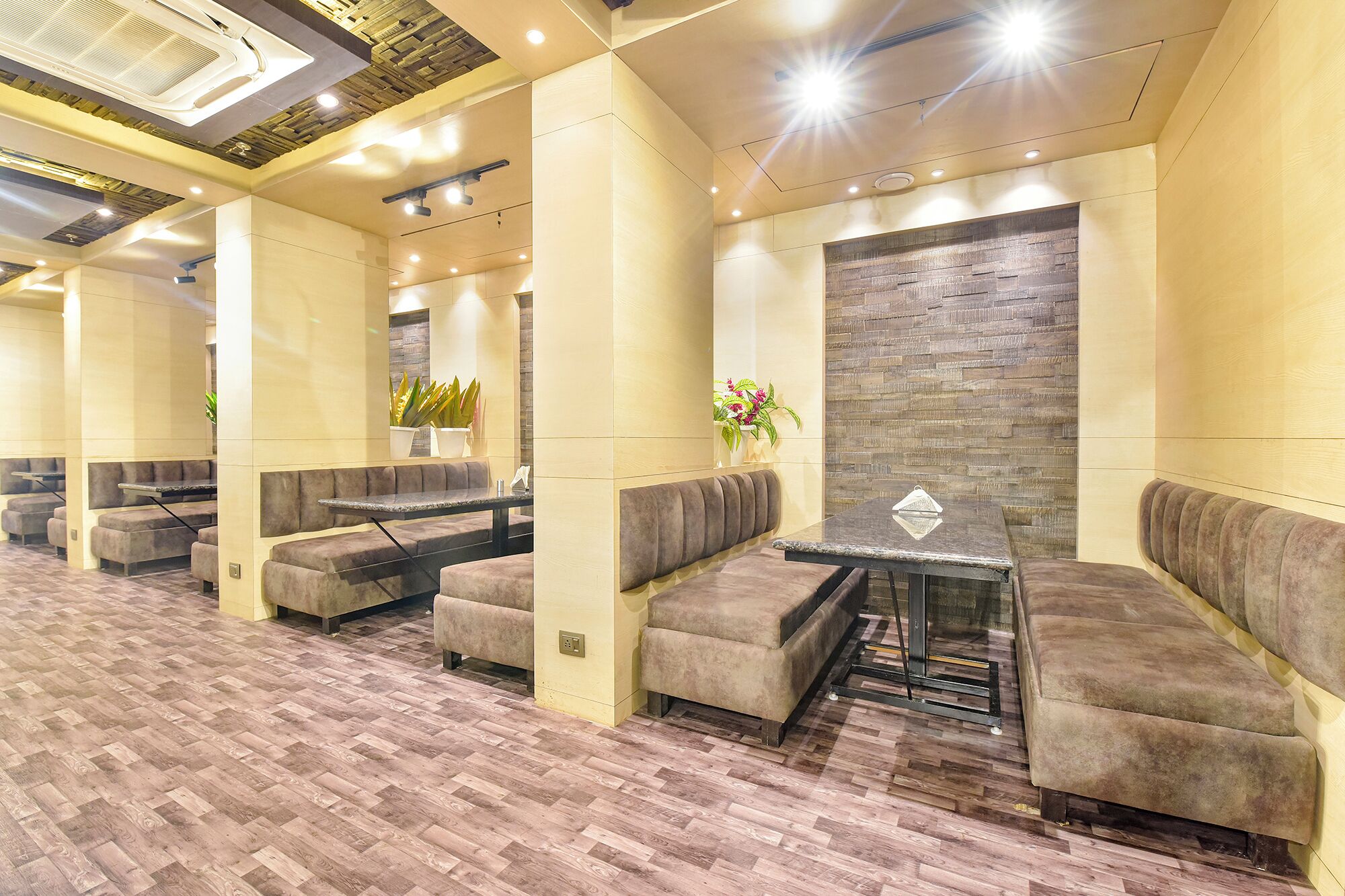 A modern lounge area with cushioned seating, a central table, and a decorative wall.