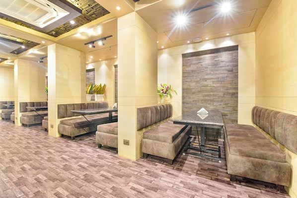 Un espace détente moderne avec des sièges confortables, une table centrale et un mur décoratif.