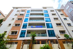 A multi-story hotel with a modern facade, balconies, and a sign for 'Fab Hotels'. - Fabhotel Rs (Hyderabad)