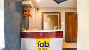 A reception desk with a 'fab hotels' logo, a wooden door labeled '101', and a security camera above the desk. - Fabhotel Dream Inn (Bhopal)