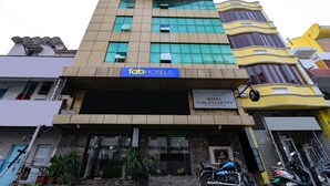 A multi-story hotel with a modern facade, a prominent sign for 'fabHOTELS', and a sign for 'HOTEL LAILA'S CO'. - Fabhotel Lailas County (Puducherry)