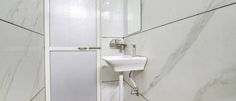 A bathroom with a white toilet, a sink, and a mirror.