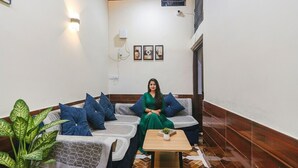 Una habitación con un sofá, una mesita y una planta en maceta.