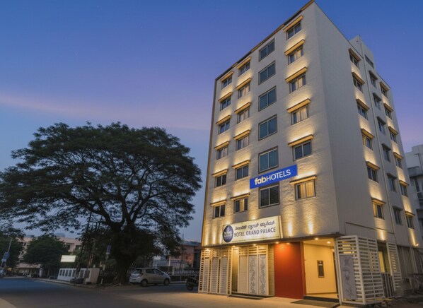 Un hôtel à plusieurs étages, avec une enseigne indiquant « fabHOTELS » et « HOTEL GRAND PALACE ».