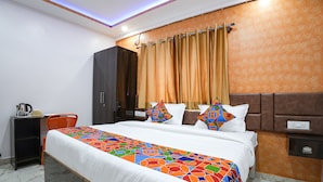 Quarto de hotel com cama, escrivaninha e cadeira.