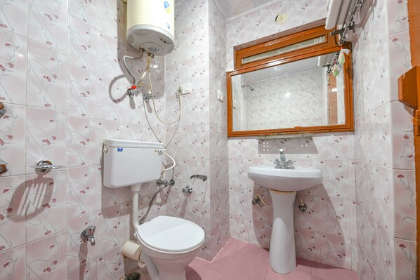 A bathroom with a toilet, sink, and mirror. - Fabhotel Zarim (Manali)
