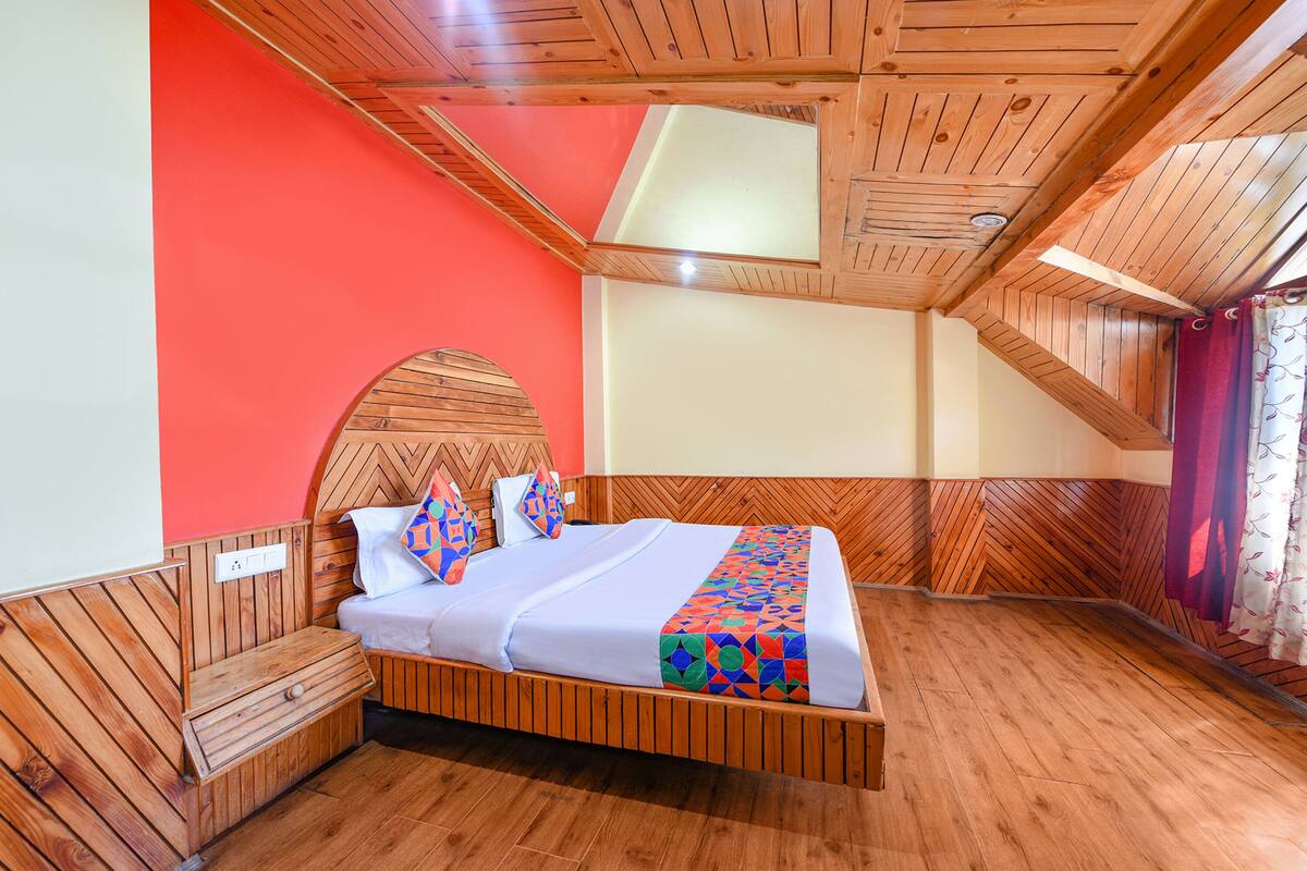 A wooden-framed room with a bed, a nightstand, and a window with curtains.