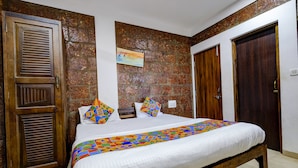 Un dormitorio con una cama, puertas de madera y una pared de ladrillo.