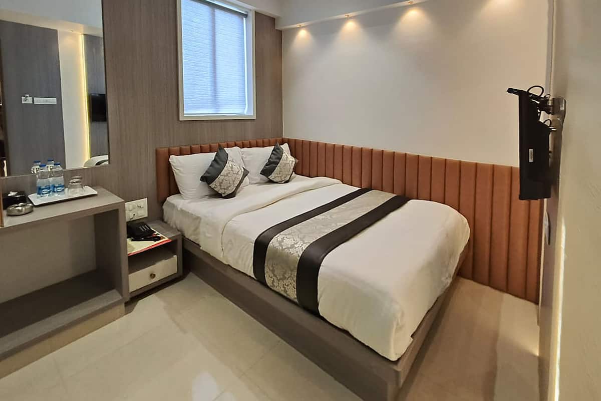 Une chambre d’hôtel moderne équipée d’un lit, d’une table de chevet et d’un miroir.