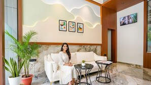A modern lobby with a white sofa, two round tables, and potted plants. - Fabhotel Melody Boutique (Thane)